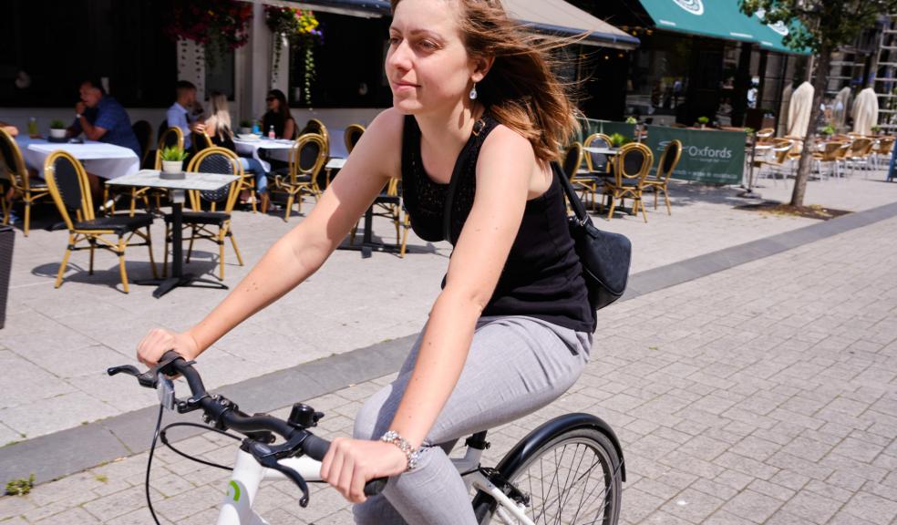 Closing roads to motor traffic can make more space for socially distanced travel Woman cycling on high street that has been closed to motor traffic