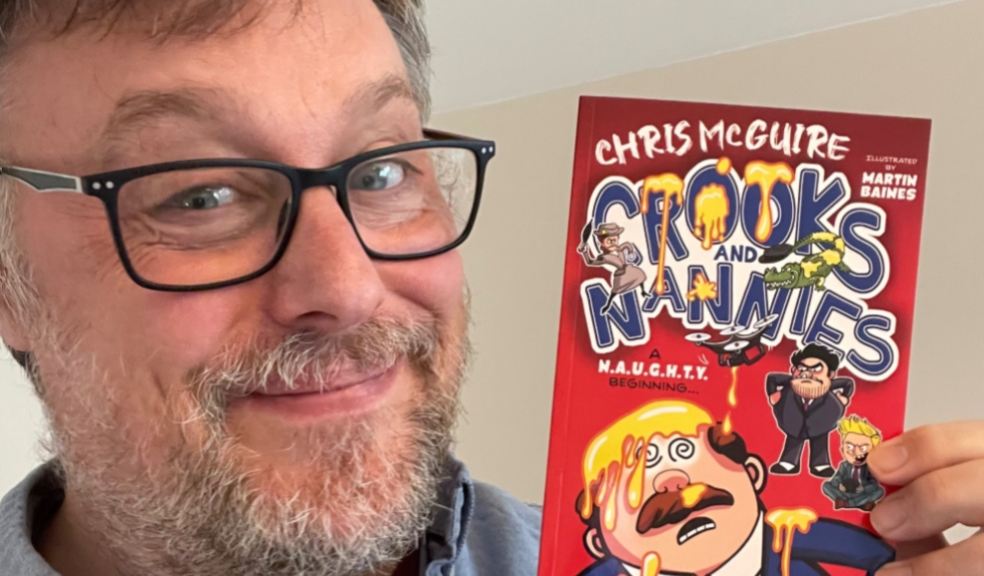 Chris McGuire holding his book