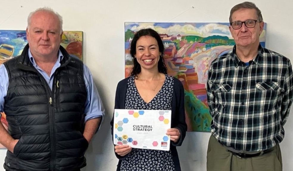 Councillor Paul Arnott with EDDC’s new cultural producer Sarah Elghady and Cllr Nick Hookway. The paintings in the background are by artist Michael Buckland. Photo: EDDC.