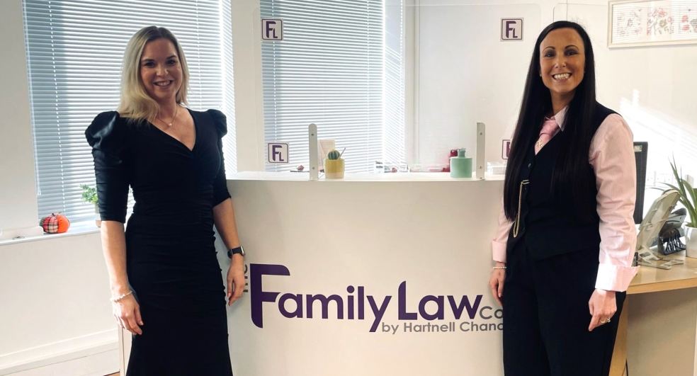 Two directors from The Family Law Company standing in front of a reception desk