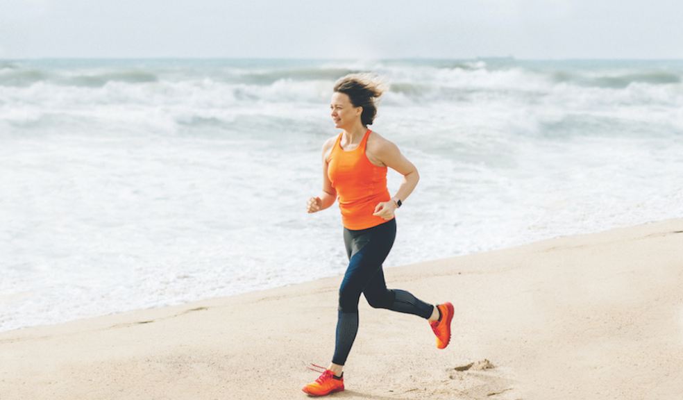 Running challenges Woman running along a beach close to the shoreline