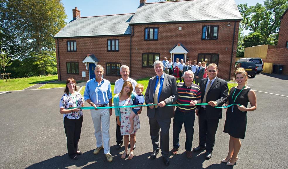 Resident Gemma Gill and son Oscar cut the ribbon at the opening of Nine Barrow view in Steppes (from left): Lisa Sparshott, Raglan Development Officer; Richard Drax MP; Richard Stevenson, Raglan Business Development Director; residents: Gemma and Oscar Gill; Peter Hammond, Raglan Board Member; Cllr Peter White-Langton, Matravers Parish Council; Andy Durant, Contracts Manager, CG Fry and Son; Rebekah Terrell, Raglan Regional Housing Manager.