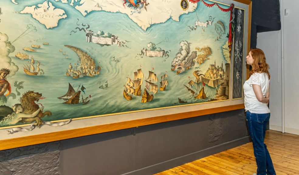 Visitors viewing The Armada off the South Coast of England. A mural of Drake's flagship by Roland Pym currently on display in the Nave at Buckland Abbey. Credit National Trust Images Barry Mitchell.