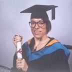 Jen Statterley in graduation outfit holding a scroll