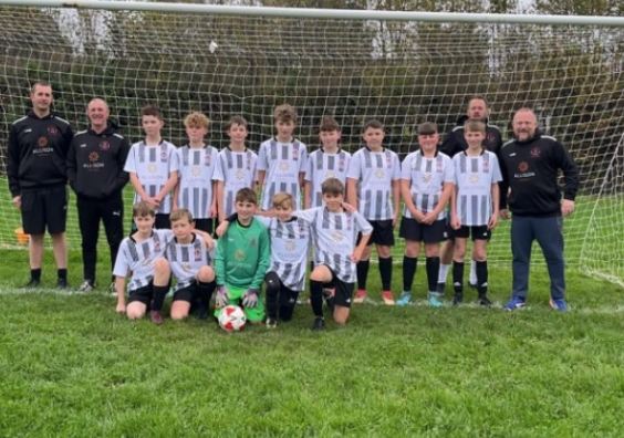 young footballers in front of goal post on football field in Devon