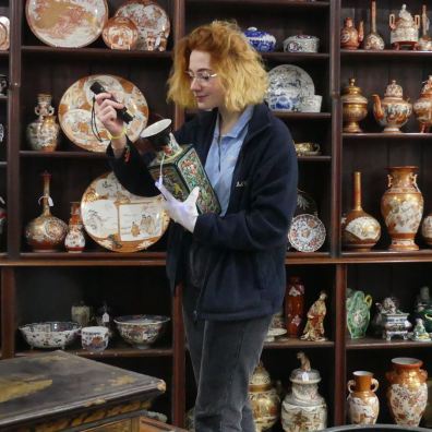 Auctioneer studying Asian art