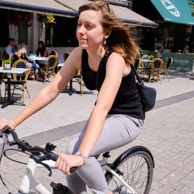 Woman cycling on high street that has been closed to motor traffic