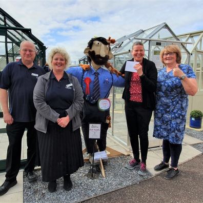 Group of people with a competition winning scarecrow