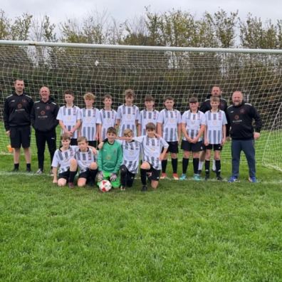 young footballers in front of goal post on football field in Devon