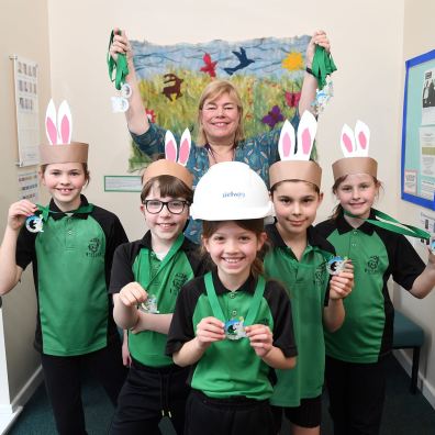 Anne Hawkins, headteacher of Willand School, and pupils with the Easter medals donated by Bellway.