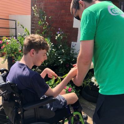 charity worker helping young boy in wheelchair 