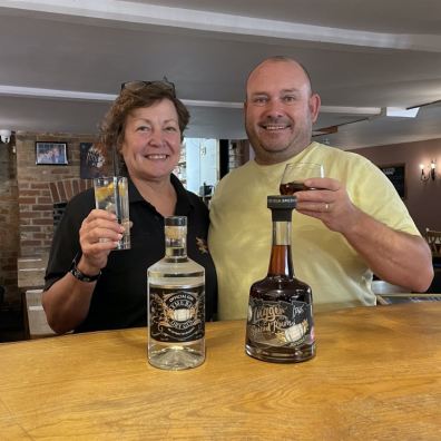 man and woman tasting a bottle of gin