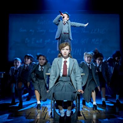 Matilda on stage with cast in background