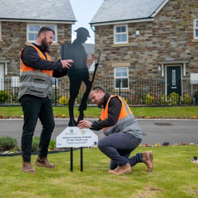 site managers installing Tommy figure at Braid Park, Tiverton