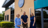 Three people stood outside a Porter Dodson office