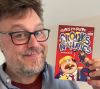 Chris McGuire holding his book