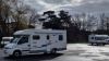 Motorhomes parked with trees behind