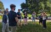 A group of people stand outside at Saltram listening to the instructor 