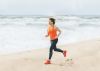 Woman running along a beach close to the shoreline