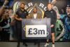 Celebrity Chef Michael Caines, with two Exeter Chiefs rugby players holding  a £3 million board 