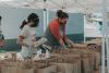 Two women in masks packing food bags